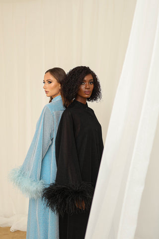 Models wearing Atelier Loreen’s Green Label garments, featuring eco friendly, handmade designs crafted in a female led atelier in Dubai. Showcasing luxury structured fabrics with feathered cuffs in black and blue.